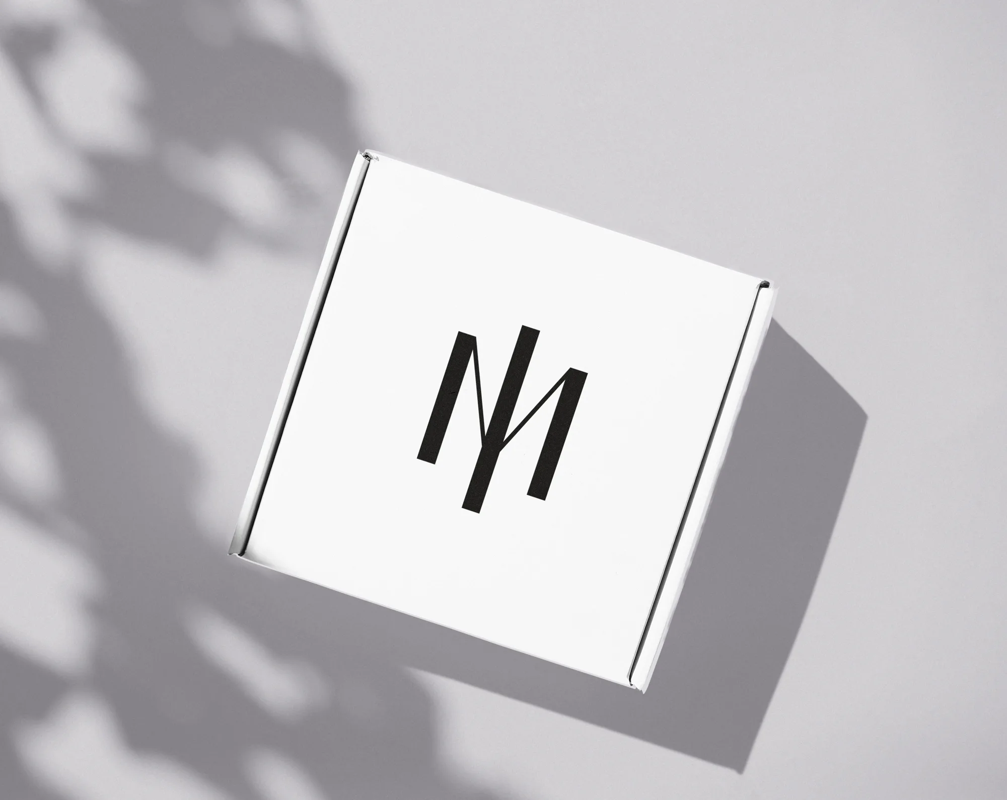 Representación de una caja de carton blanca para empaque de productos con el Símbolo al centro.